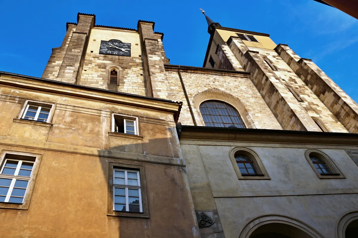 The tower and gable of St Giles' Church seen from below, with a clock face on the tower and an arched doorway at the foot of the wall.